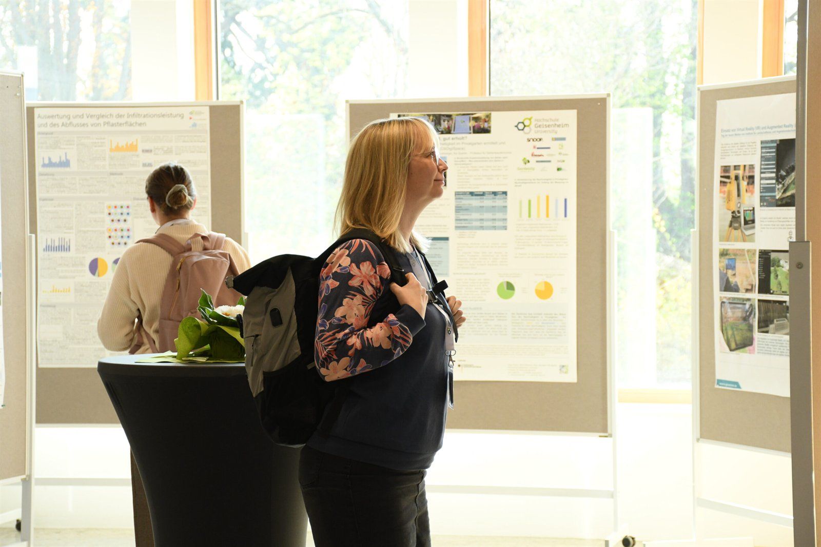 Teilnehmende betrachten Posterwände im Foyer