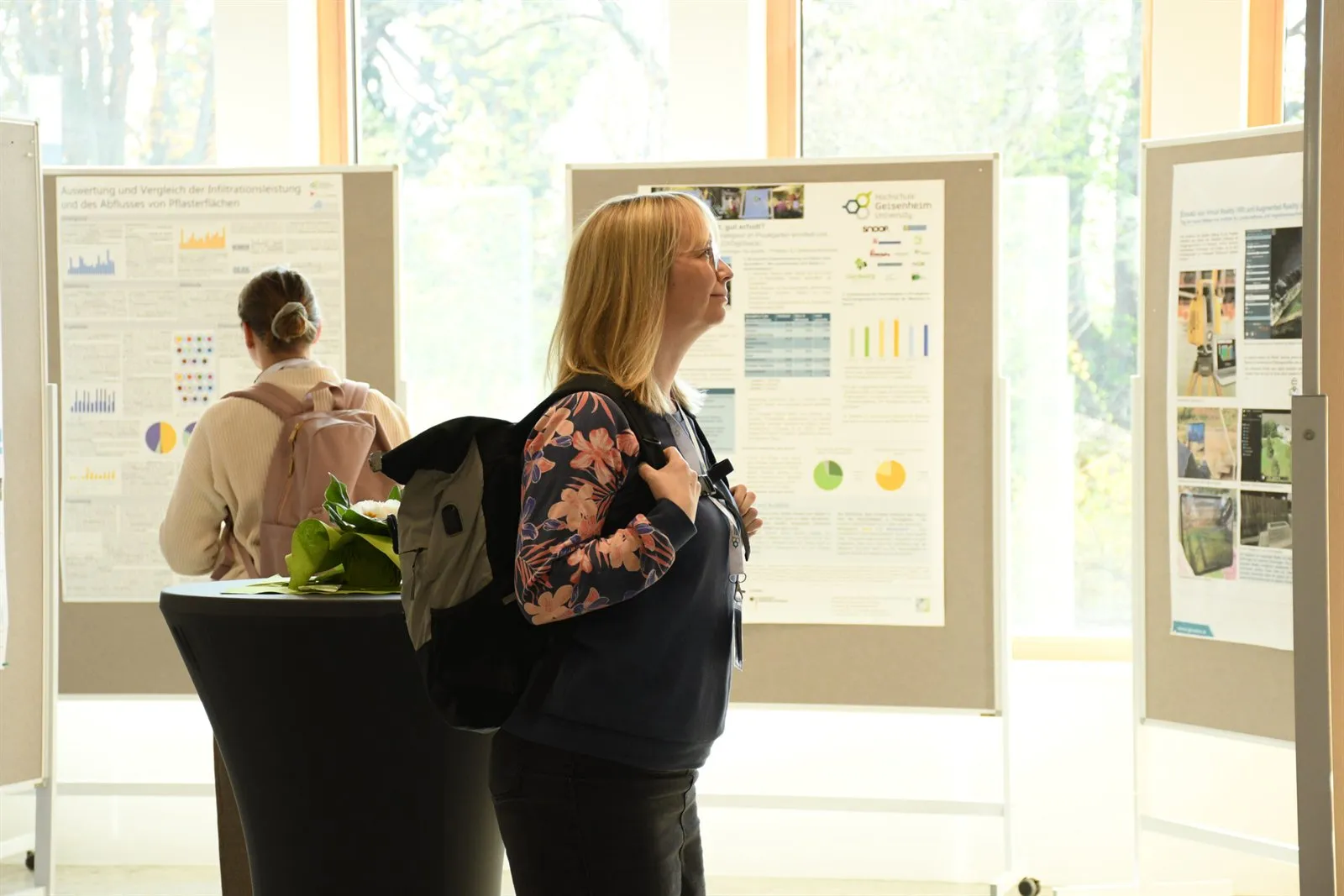 Teilnehmende betrachten Posterwände im Foyer