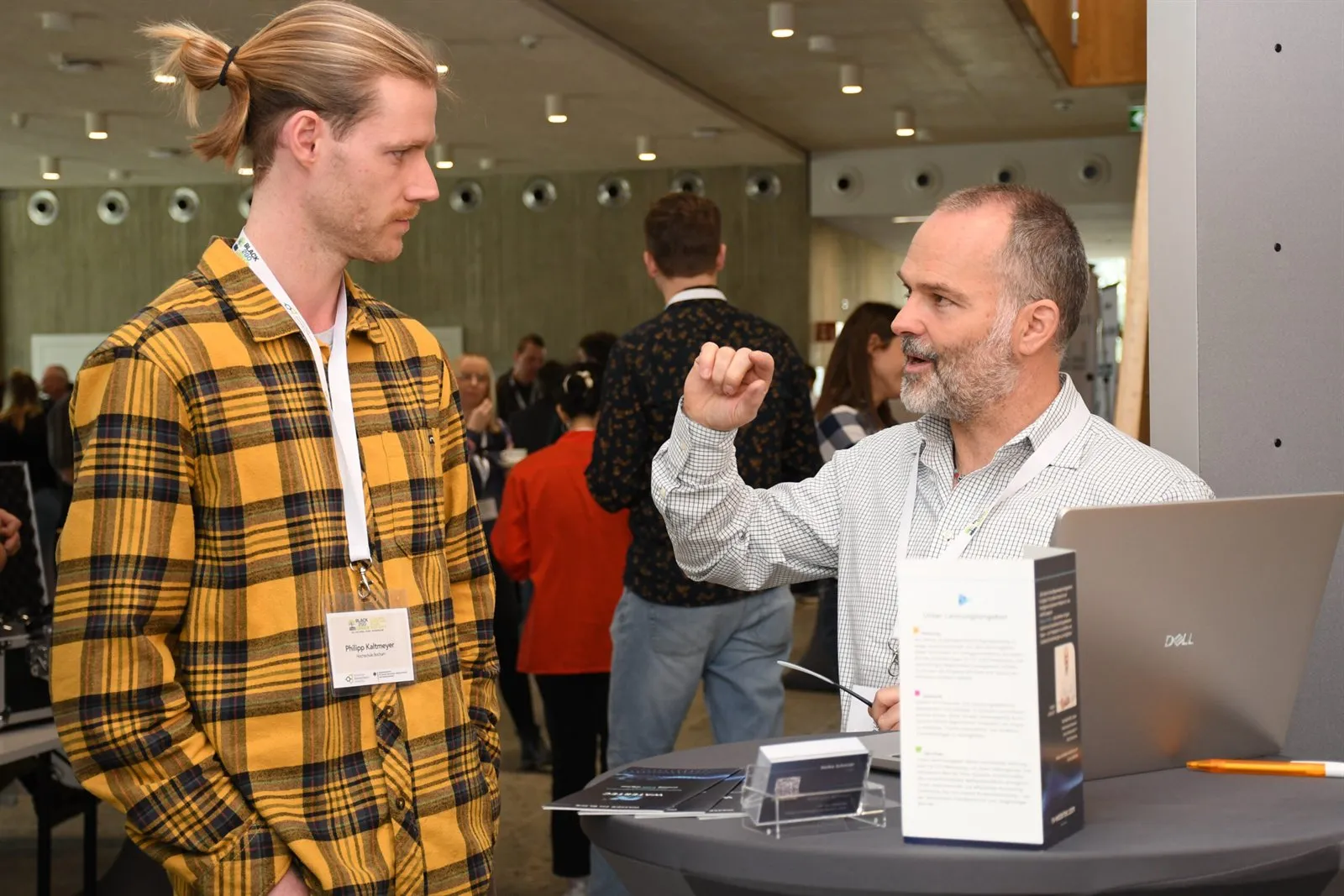 Gespräch zwischen Teilnehmenden an einem Ausstellungsstand