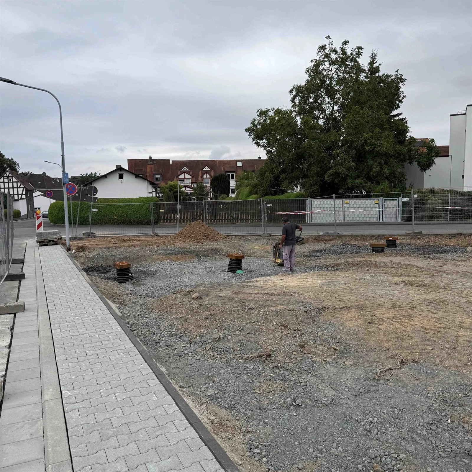 Baustelle mit frischem Gehwegpflaster und Bestandsbaum