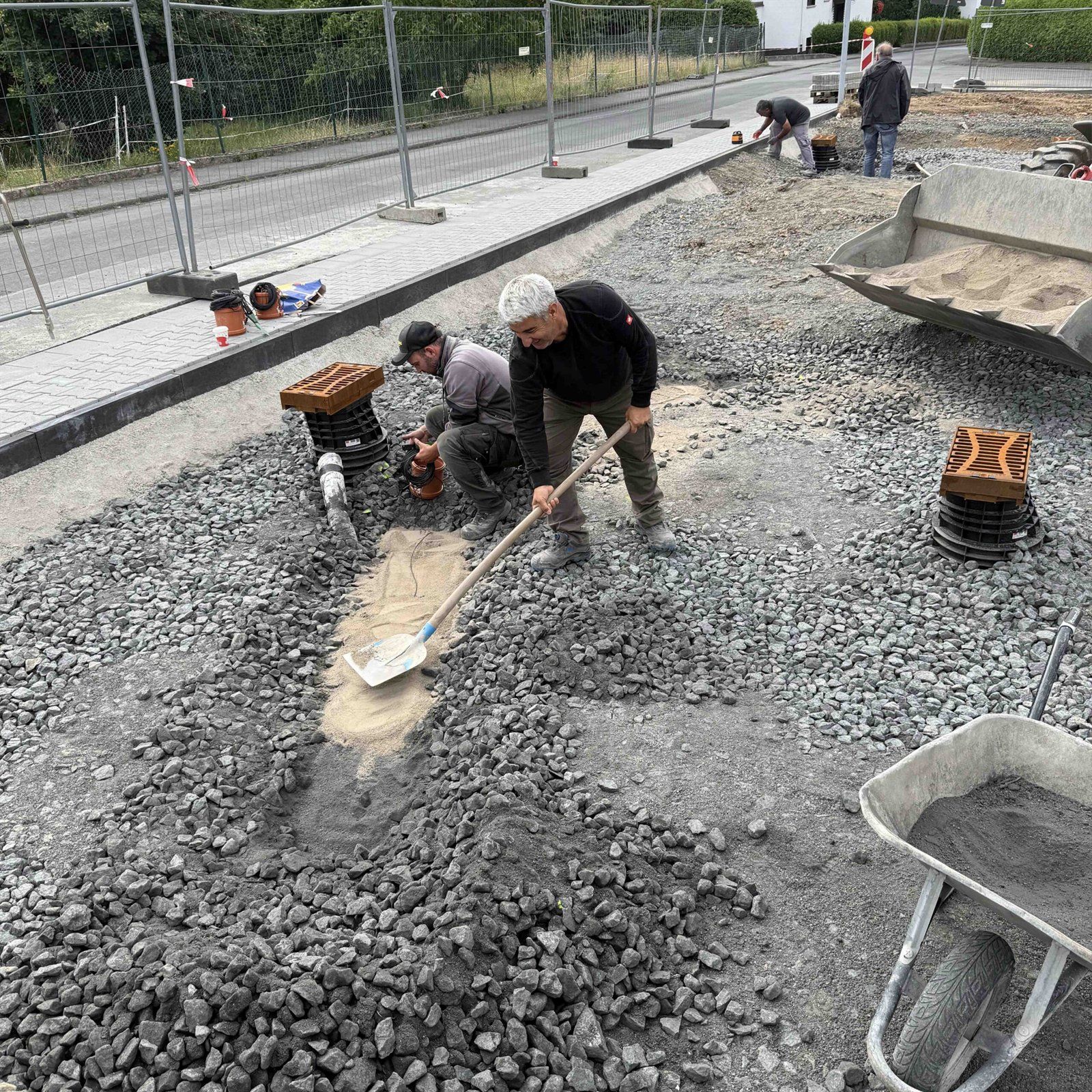 Arbeiter verteilen Substrat in einer Baumgrube im Reallabor Wettenberg