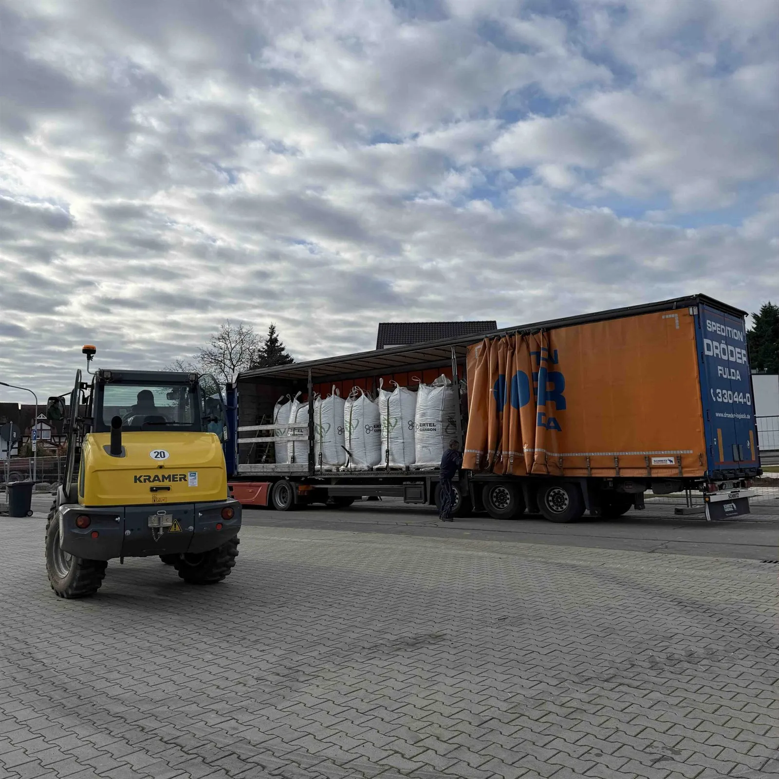 Lkw mit Big Bags und Radlader auf einem Parkplatz
