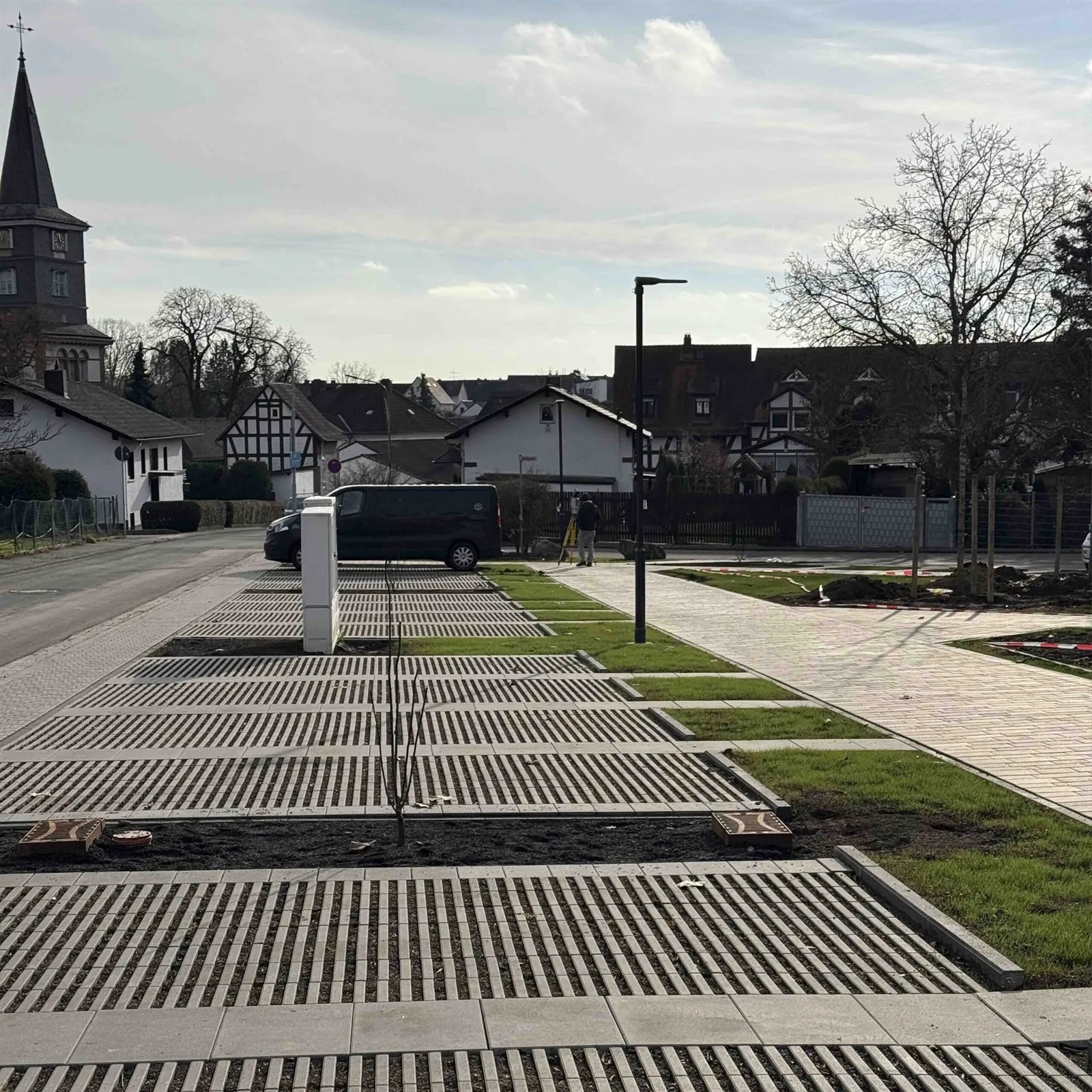 Fertig gepflasterte Fläche mit Baumscheiben und jungen Bäumen
