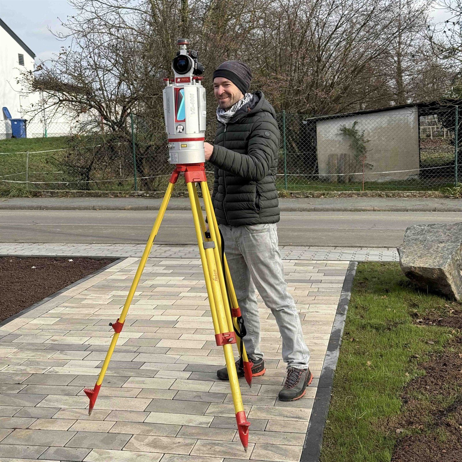 Person mit Laserscanner auf einem Stativ an einem neu angelegten Platz