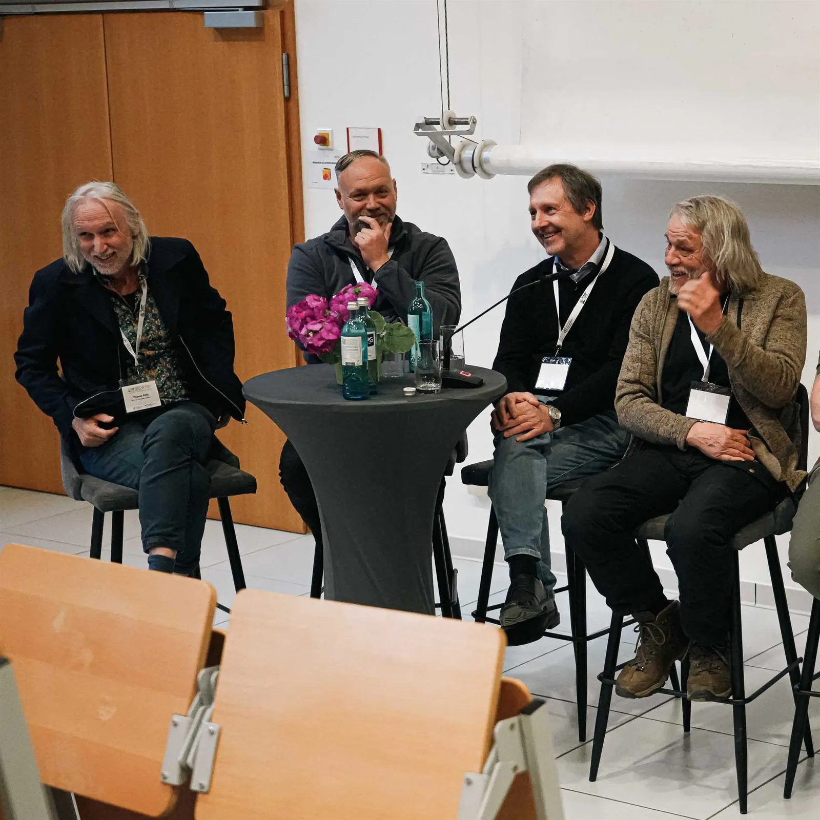 Podiumsdiskussion mit vier Personen auf Barhockern