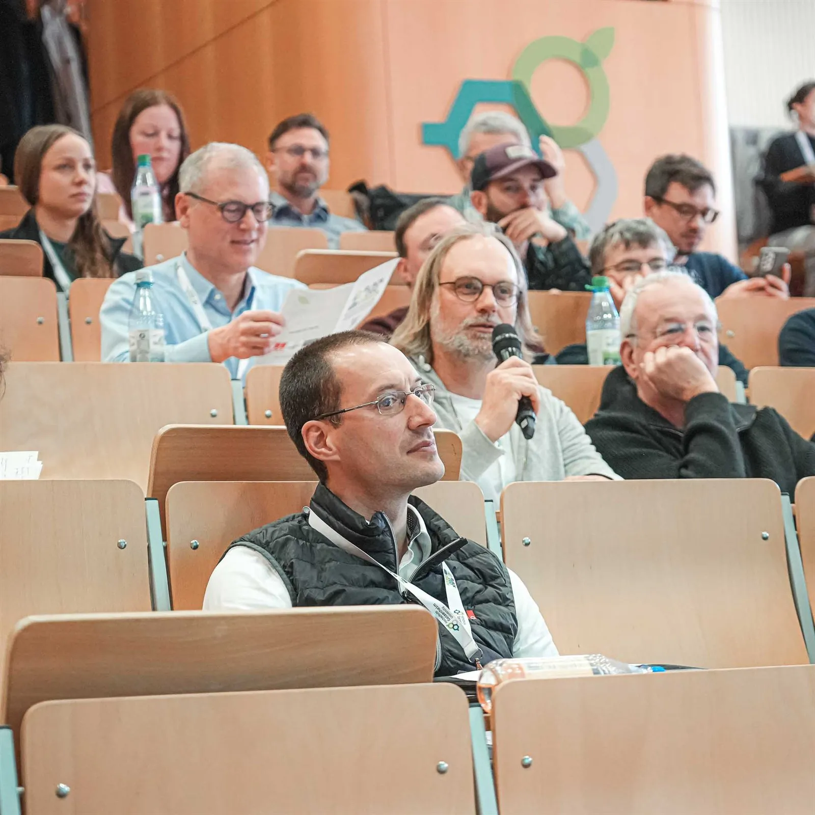 Teilnehmende im Hörsaal folgen einem Vortrag