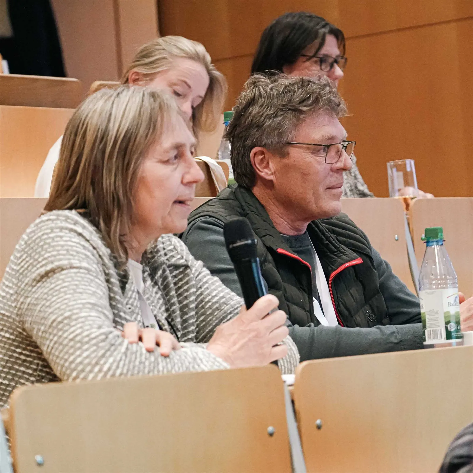 Zwei Teilnehmende sprechen in der Diskussion ins Mikrofon