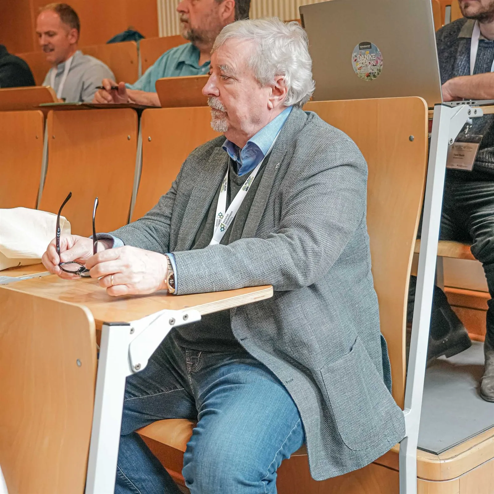 Älterer Teilnehmer in einer Sitzreihe des Hörsaals