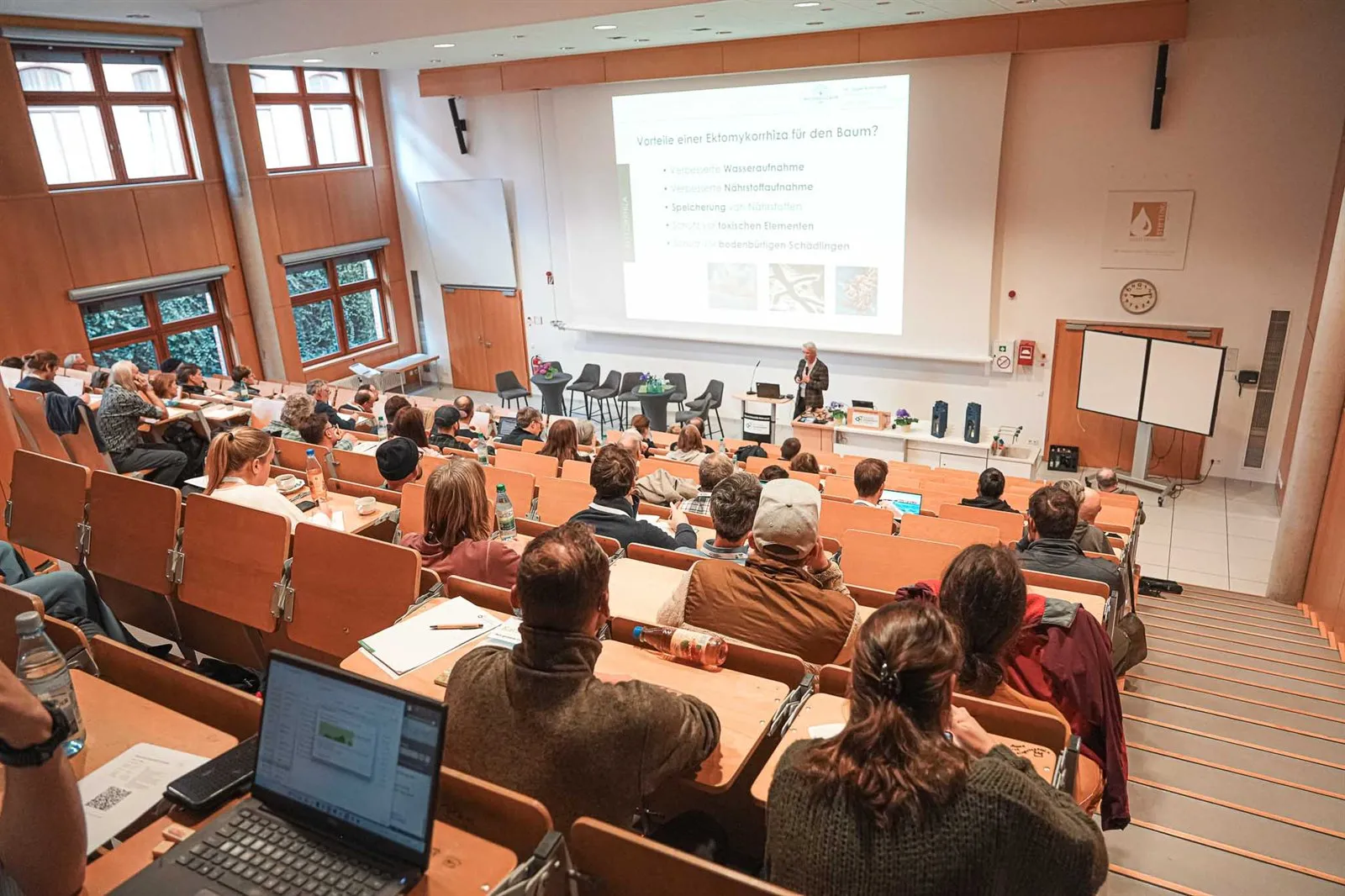 Blick von oben in den voll besetzten Hörsaal während eines Vortrags