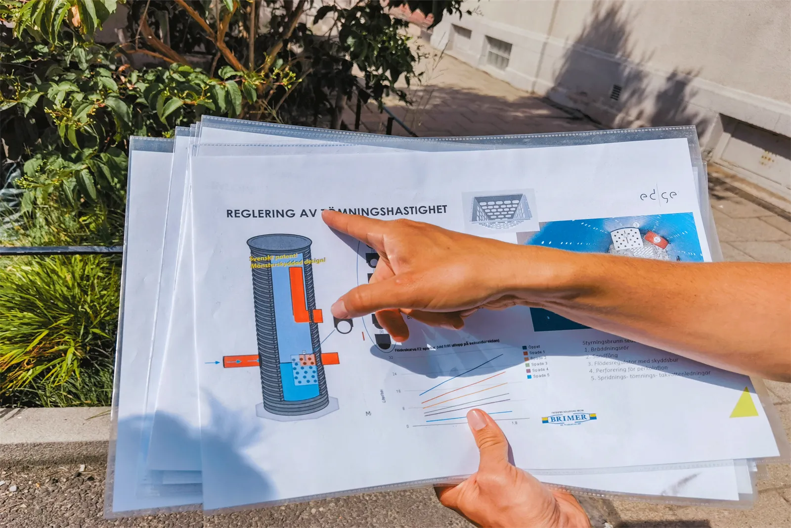 Finger zeigt auf eine Grafik zur Regenwasserversickerung auf einem laminierten Blatt