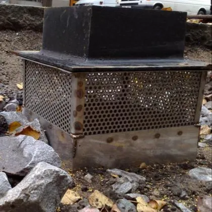 Belüftungsbrunnen aus Metall auf grobem Schotter