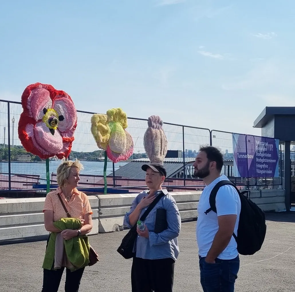 Drei Personen auf einer Aussichtsterrasse an der Baustelle Slussen, im Hintergrund das Wasser