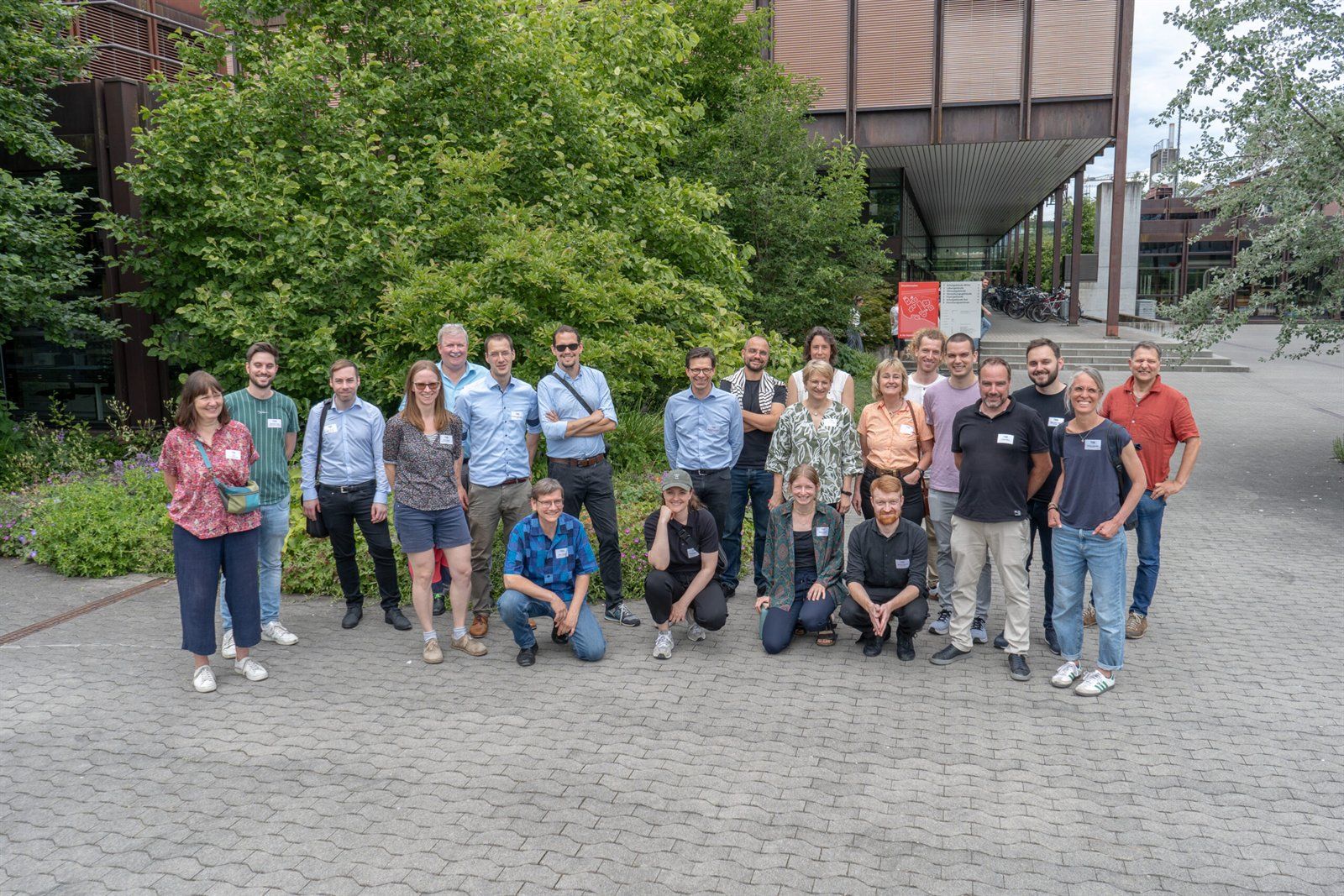 Gruppenfoto der Teilnehmenden des BlueGreenStreets-Netzwerktreffens vor einem Hochschulgebäude mit Bäumen